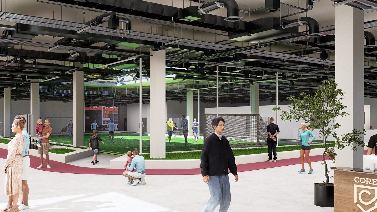 Inside The Core: people crossing the open floor past the turf pitch, under the exposed industrial ceiling